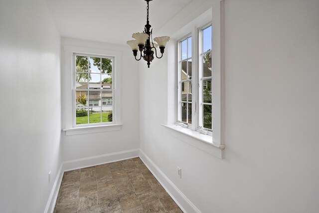 468 Van Buren St, Ridgewood, NJ 07450 - unfurnished dining area with baseboards, a chandelier, and stone finish flooring