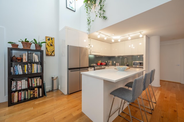 kitchen with decorative backsplash, white cabinetry, appliances with stainless steel finishes, and modern cabinets