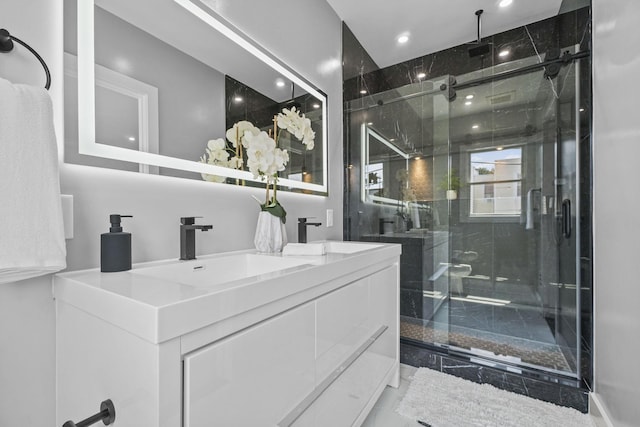 bathroom with double vanity, a sink, and a shower stall