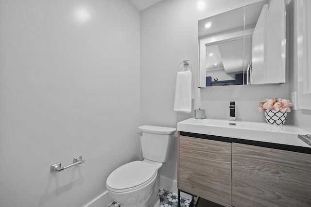 bathroom featuring toilet, recessed lighting, baseboards, and vanity