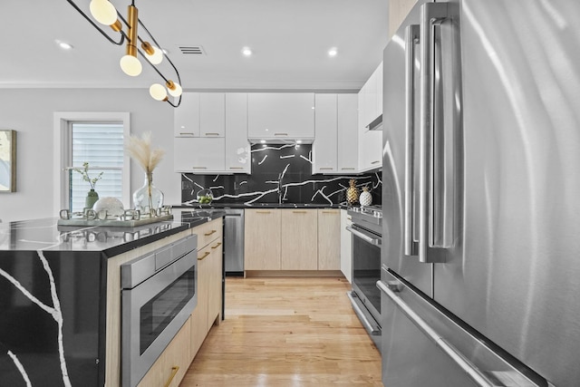 kitchen featuring pendant lighting, stainless steel appliances, dark countertops, white cabinets, and modern cabinets