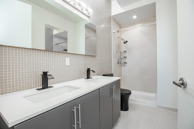 bathroom with tiled shower, tile patterned floors, toilet, tasteful backsplash, and vanity