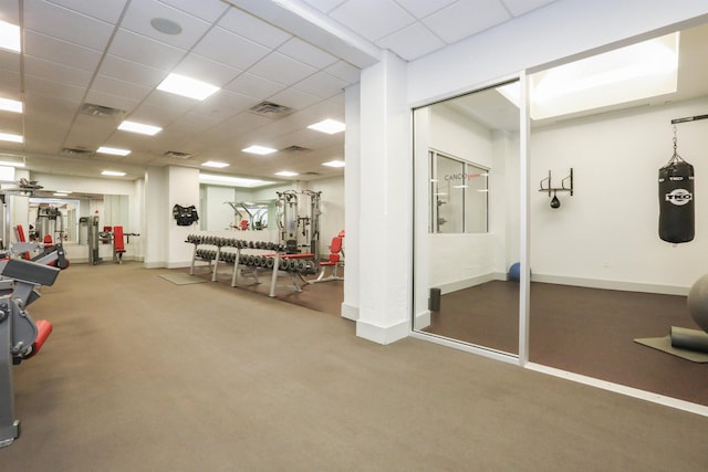 gym featuring a paneled ceiling and carpet