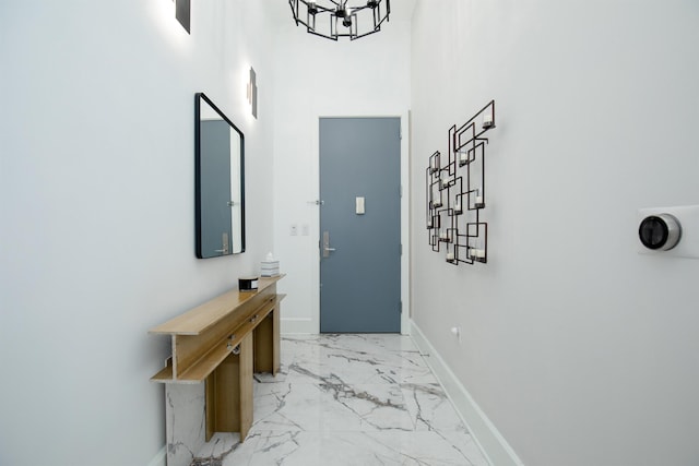 corridor featuring a high ceiling and an inviting chandelier