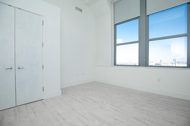 unfurnished bedroom featuring light hardwood / wood-style flooring and a closet