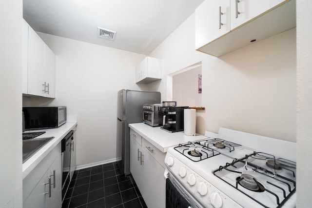 kitchen featuring visible vents, dark tile patterned flooring, a sink, gas range gas stove, and light countertops