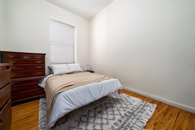 bedroom with baseboards and wood finished floors