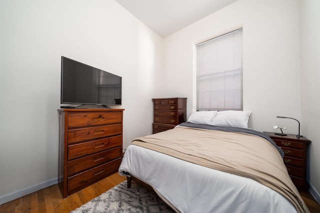 bedroom with wood finished floors and baseboards