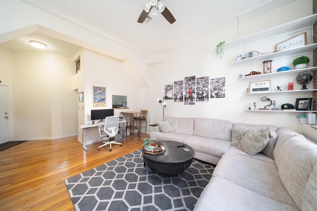 living room featuring visible vents, baseboards, a ceiling fan, and wood finished floors