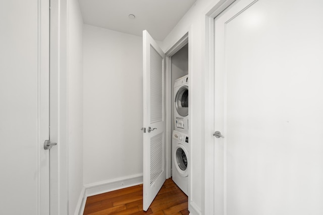 laundry area with hardwood / wood-style floors and stacked washer / dryer