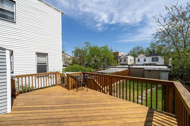 wooden deck with a storage unit and an outbuilding