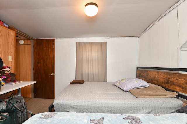 bedroom featuring carpet floors and wooden walls