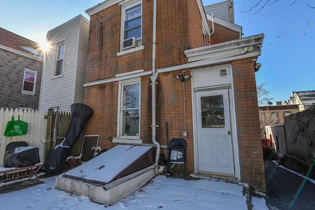 view of snow covered back of property