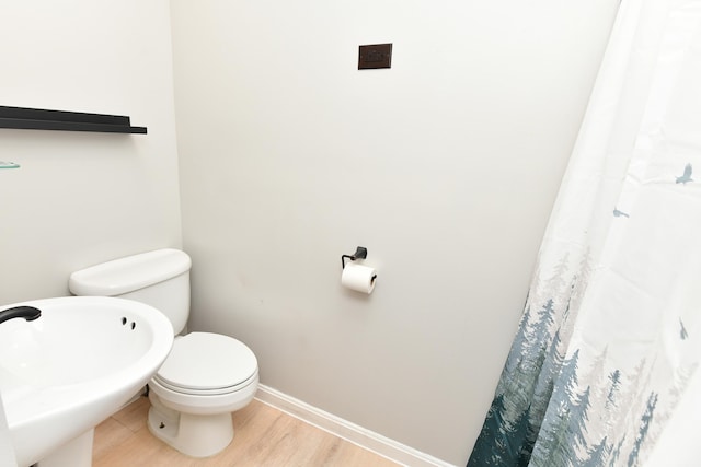 bathroom with hardwood / wood-style flooring and toilet