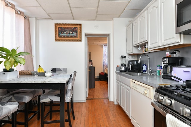 kitchen featuring stainless steel appliances, sink, a paneled ceiling, and white cabinets