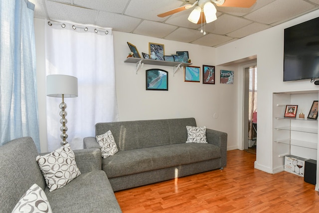 living room with ceiling fan, a paneled ceiling, and hardwood / wood-style floors