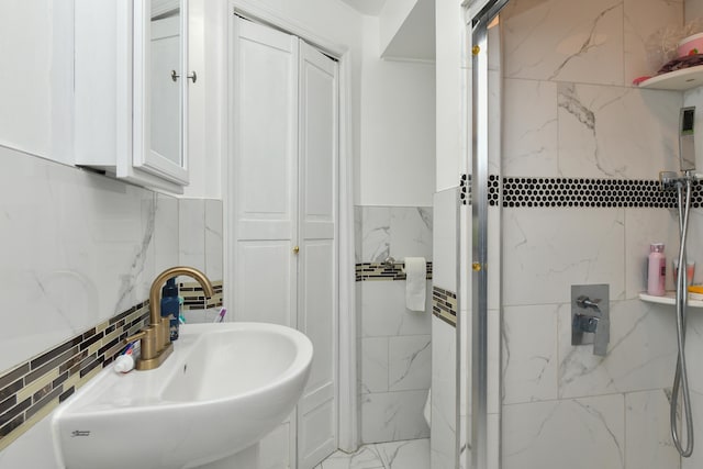 bathroom featuring tasteful backsplash, sink, and a shower with shower door