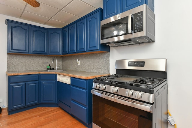 kitchen with sink, backsplash, stainless steel appliances, light hardwood / wood-style floors, and blue cabinets