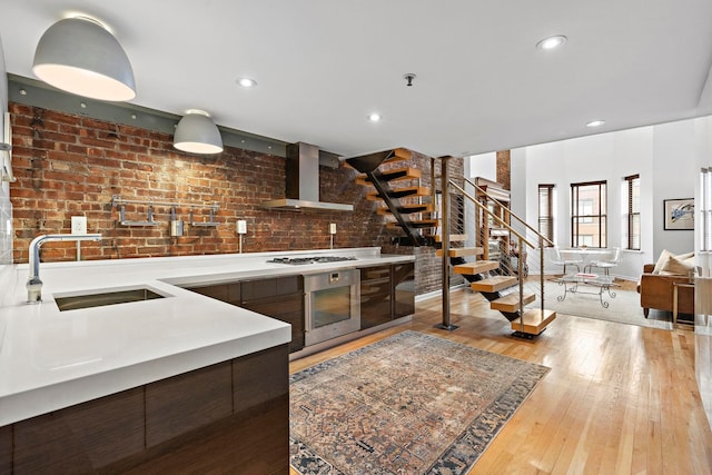 1110 Hudson St Unit 5B, Hoboken, NJ 07030 - kitchen featuring a sink, stainless steel appliances, wall chimney range hood, modern cabinets, and light countertops