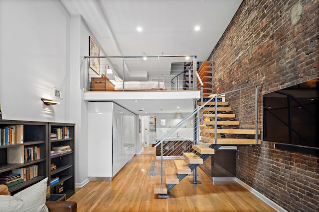 1110 Hudson St Unit 5B, Hoboken, NJ 07030 - staircase with brick wall, wood finished floors, baseboards, a high ceiling, and recessed lighting
