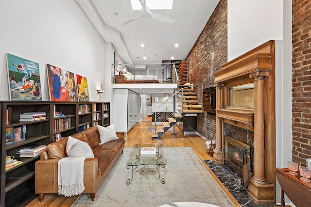 1110 Hudson St Unit 5B, Hoboken, NJ 07030 - living room featuring brick wall, wood finished floors, stairs, ceiling fan, and a fireplace