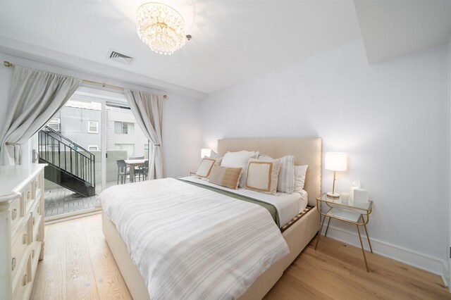 833 Willow Ave Unit 2, Hoboken, NJ 07030 - bedroom featuring light wood-style floors, a chandelier, and access to outside