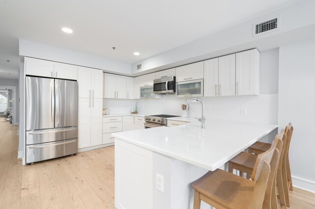 833 Willow Ave Unit 2, Hoboken, NJ 07030 - kitchen with stainless steel appliances, a peninsula, light wood finished floors, recessed lighting, and light countertops