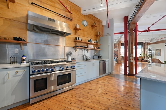 1620 Manhattan Ave Unit C3, Union City, NJ 07087 - kitchen with appliances with stainless steel finishes, exhaust hood, open shelves, tasteful backsplash, and light wood-style floors