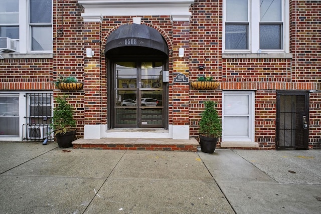 view of exterior entry featuring brick siding