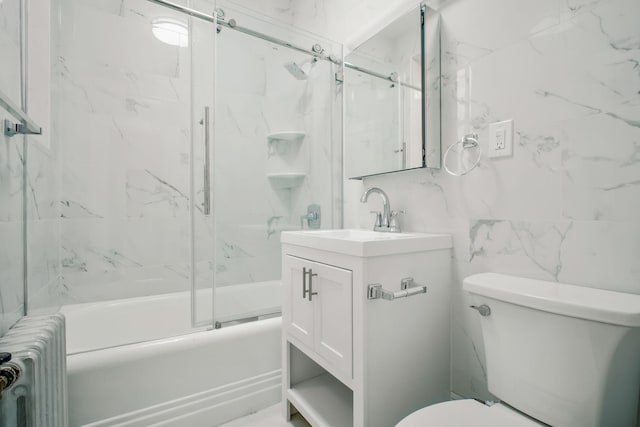 full bathroom featuring radiator, toilet, vanity, tile walls, and bath / shower combo with glass door