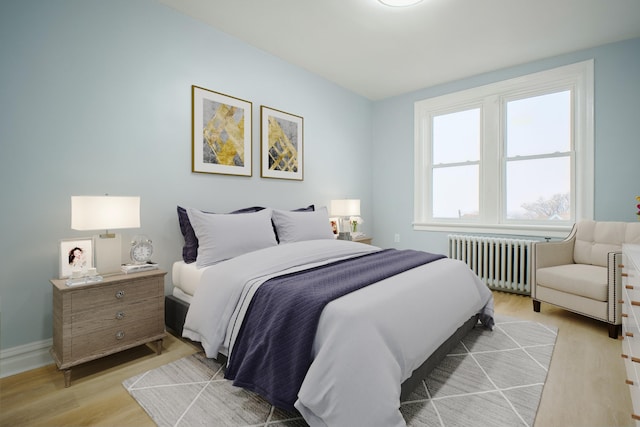 bedroom featuring radiator, light wood finished floors, and baseboards