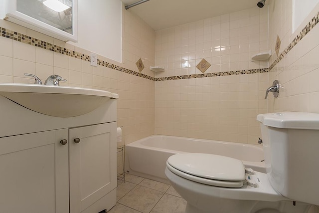 full bathroom with tile patterned floors, tiled shower / bath combo, toilet, and tile walls