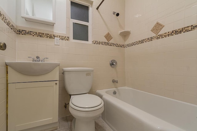 full bathroom with vanity, toilet, tile walls, and tiled shower / bath