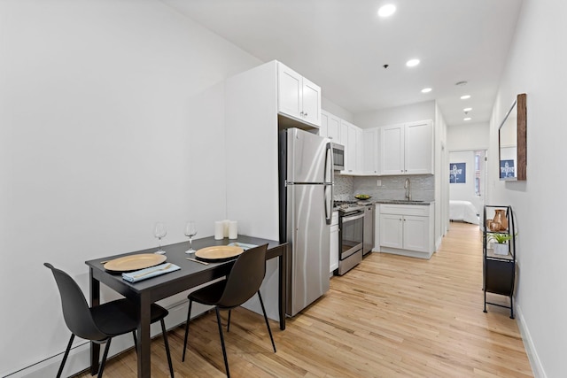 110 Washington St Unit 8, Hoboken, NJ 07030 - kitchen with stainless steel appliances, light wood finished floors, white cabinets, tasteful backsplash, and recessed lighting