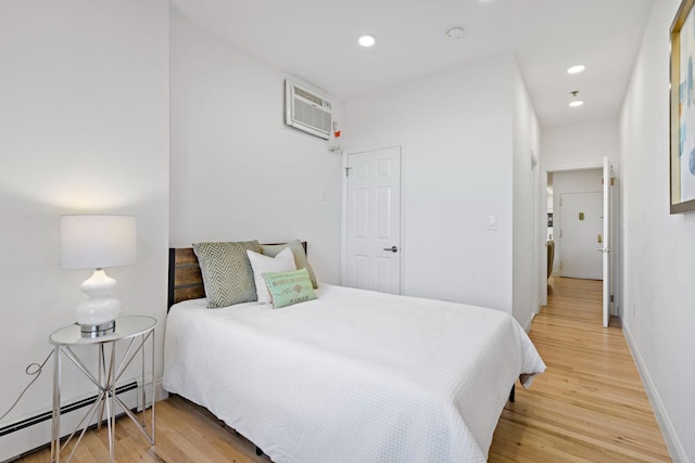 110 Washington St Unit 8, Hoboken, NJ 07030 - bedroom featuring a baseboard heating unit, a wall mounted AC, light wood finished floors, and recessed lighting