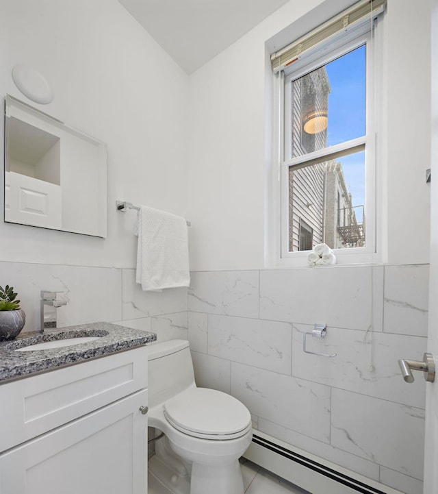 110 Washington St Unit 8, Hoboken, NJ 07030 - half bath featuring tile walls, a baseboard radiator, vanity, and wainscoting