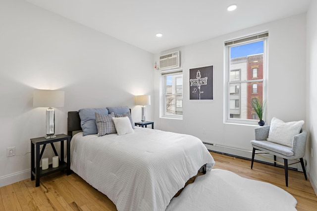 110 Washington St Unit 8, Hoboken, NJ 07030 - bedroom with baseboard heating, an AC wall unit, light wood-style floors, and recessed lighting