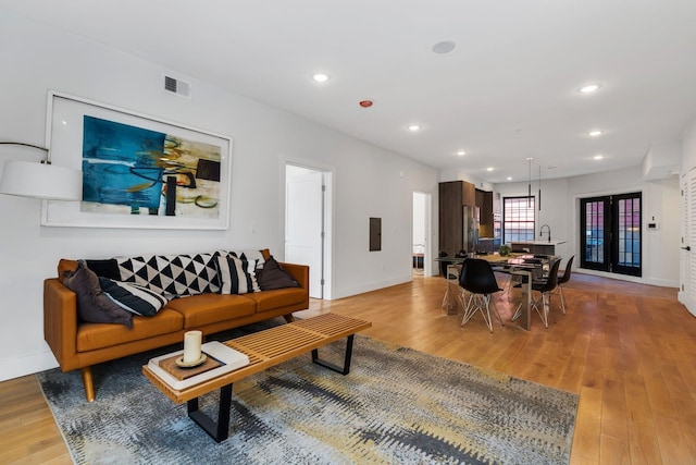 living room with french doors and light hardwood / wood-style floors