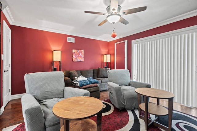 living area with ceiling fan, visible vents, crown molding, wood finished floors, and baseboards