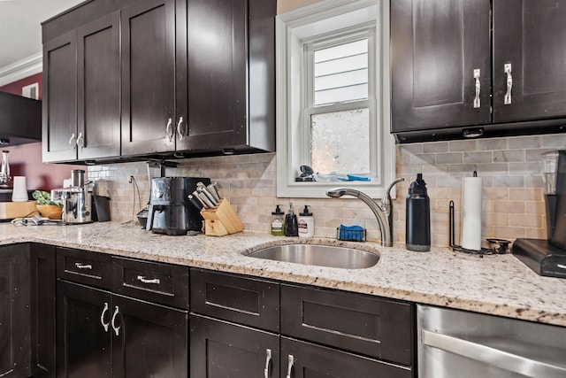 kitchen featuring stainless steel dishwasher, dark brown cabinetry, decorative backsplash, and a sink