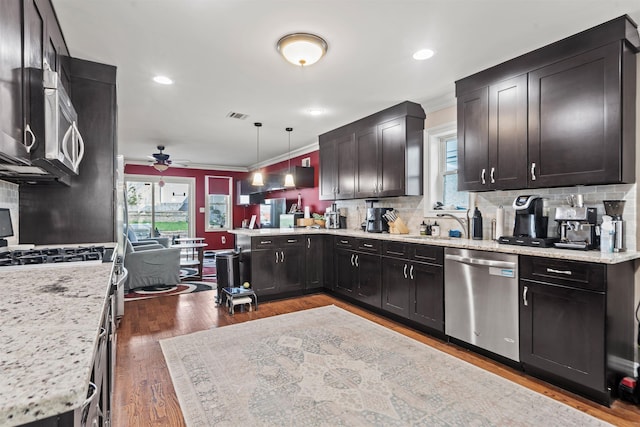 kitchen featuring crown molding, a ceiling fan, appliances with stainless steel finishes, and tasteful backsplash