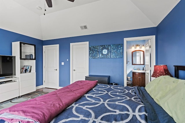 bedroom featuring visible vents, lofted ceiling, baseboards, ensuite bathroom, and a ceiling fan