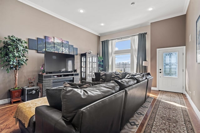 living room with crown molding, recessed lighting, baseboards, and wood finished floors
