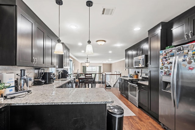 kitchen with crown molding, light stone counters, stainless steel appliances, tasteful backsplash, and dark wood-style floors
