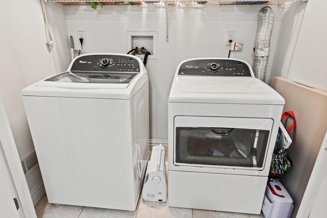 laundry room featuring laundry area, washer and clothes dryer, and light tile patterned flooring