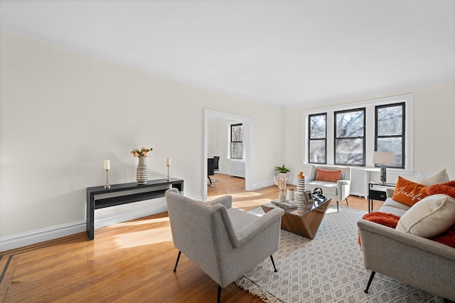 living area with baseboards and light wood finished floors