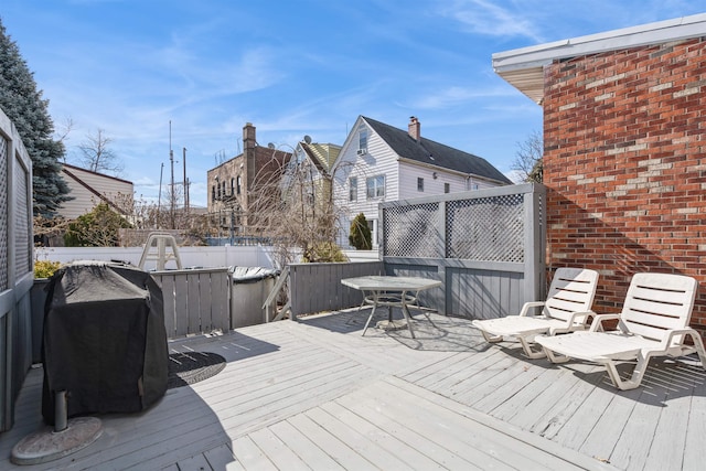 wooden terrace with fence and a grill