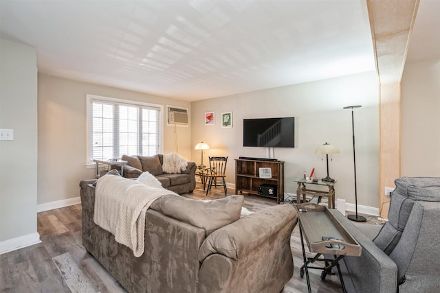 living room featuring a wall mounted AC, wood finished floors, and baseboards