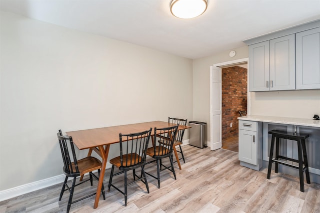 dining space with light wood finished floors and baseboards