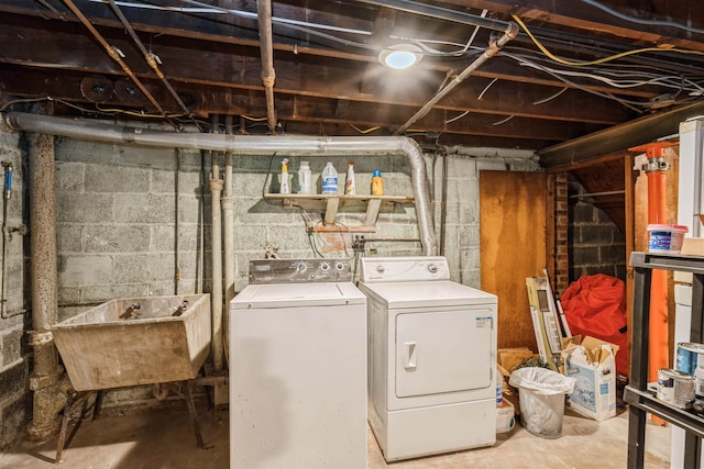 laundry area with laundry area, washer and dryer, and a sink